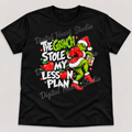 The Grinch Stole My Lesson Plan Black Gildan T-Shirt smaller centered print with faded watermark